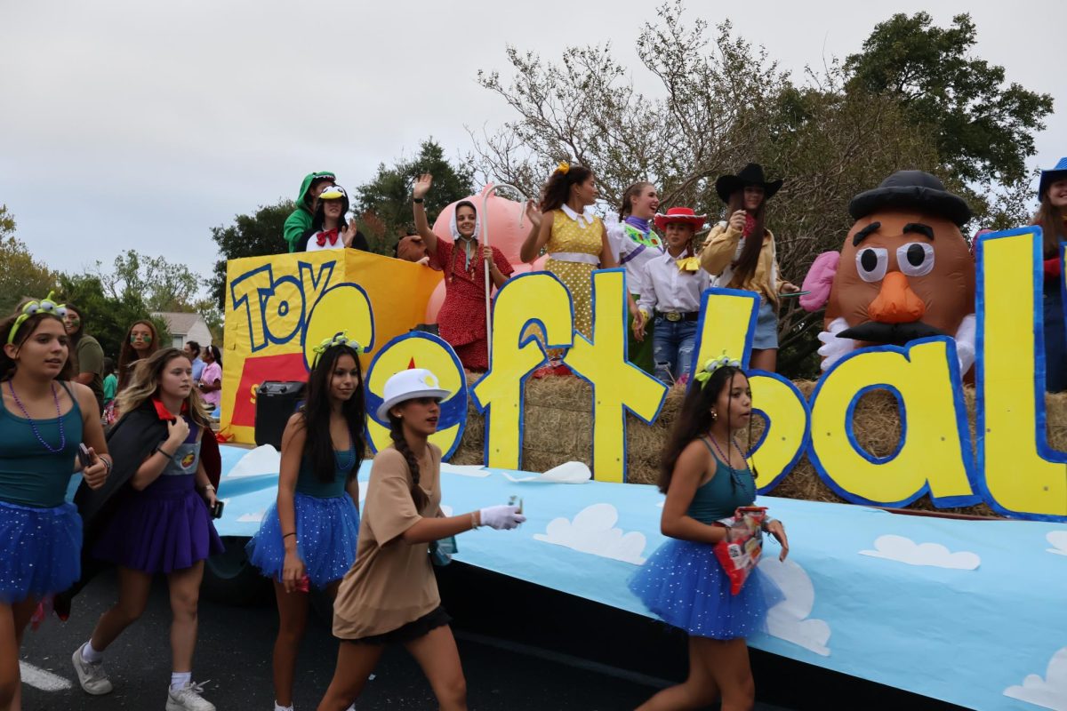 Walking in the parade, the softball team toss candy to spectators. Garnering a first-place win, the team impressed audiences with their Toy Story themed float.