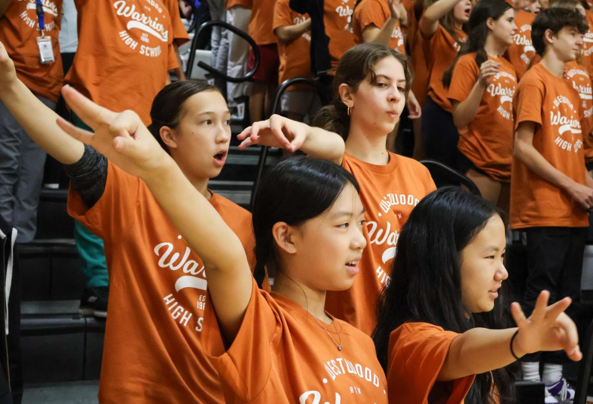 Learning the school symbol, a group of 8th graders practice the "sko wood" slogan. During the pep rally, 8th graders were introduced to Westwood spirit attributes.