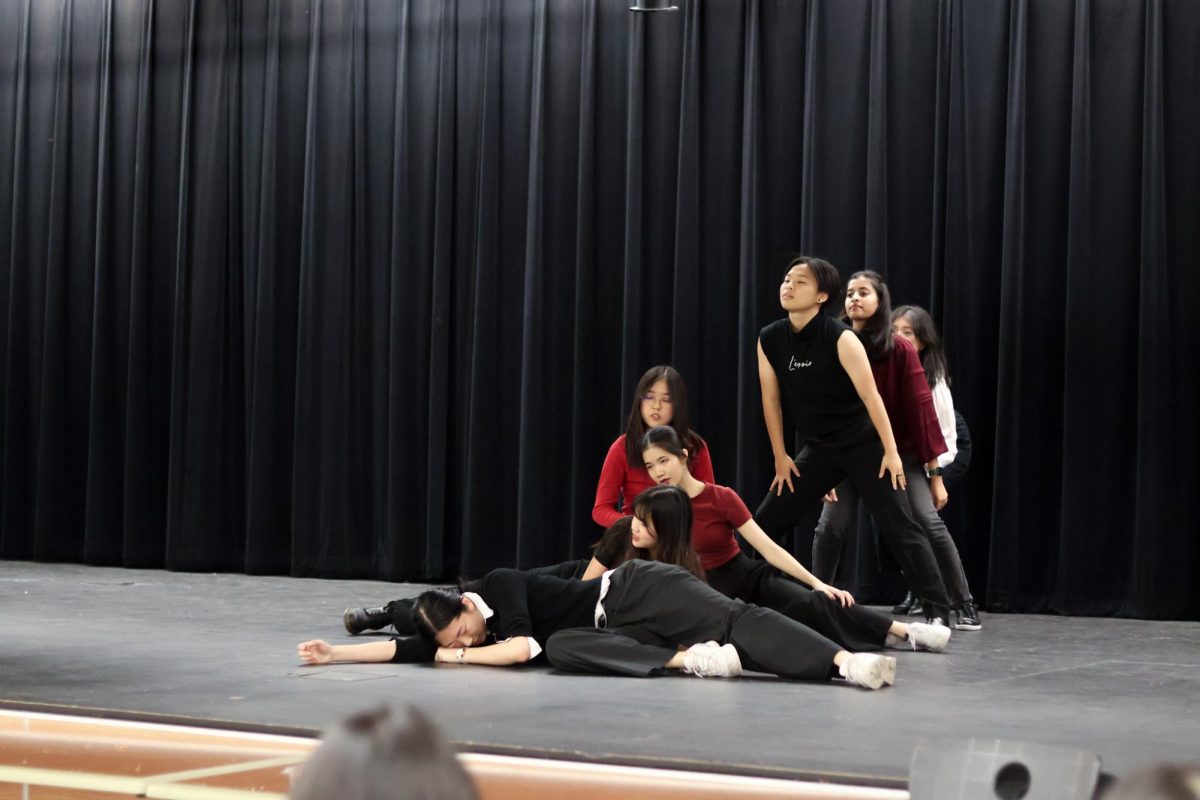 Starting off the Bite Me dance to audience cheers, K-pop club members prepared to give the performance their all. Following the red and black palette displayed in the original performance of the song, dancers embraced the theme of the dance by wearing red lipstick and dressing in darker colors. 