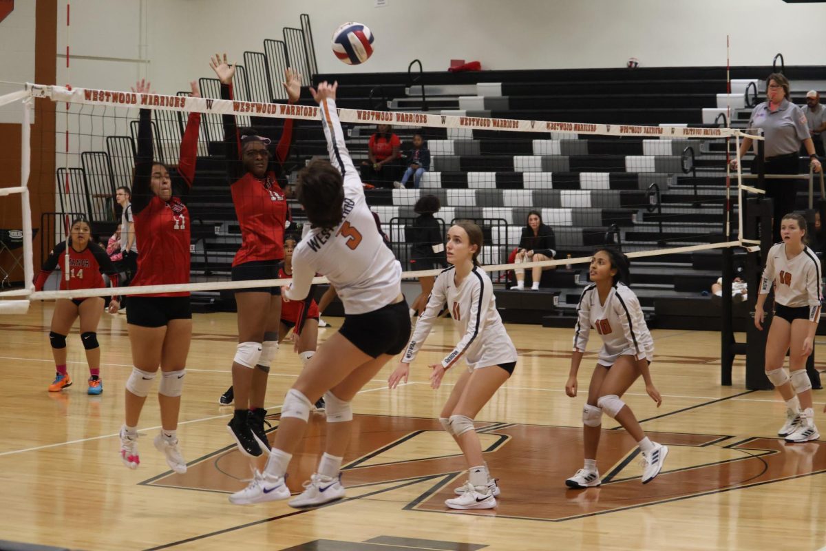 Chloe Paddock '25 spikes the ball over the  the Mustangs and to a blind spot on the court scoring another point. The Lady Warriors then huddled and celebrated gaining one of their last points needed to win the set.