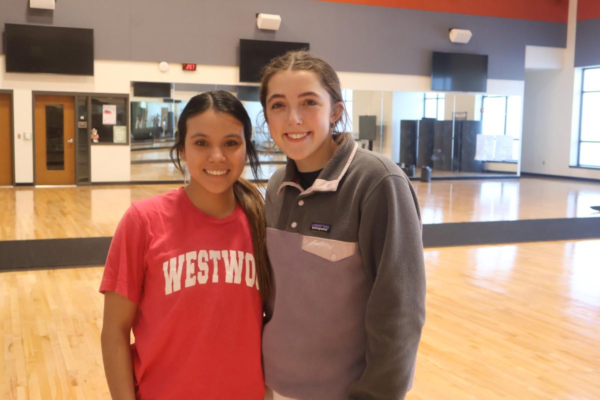 Smiling wide, Maddy Serpas '24 and Francie Smith '24 pose for a photo before practice. The two Game Day Leaders have led the team through a successful year through their leadership and example. 