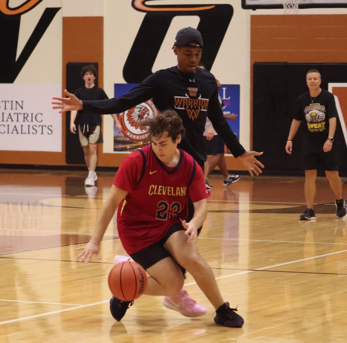 Guarded closely by Coach Dezmun Williams, Daniel Nikazm '25 dribbles down the court. The game, hosted by National Honor Society, was a fun opportunity to raise awareness and participation in the organization.
