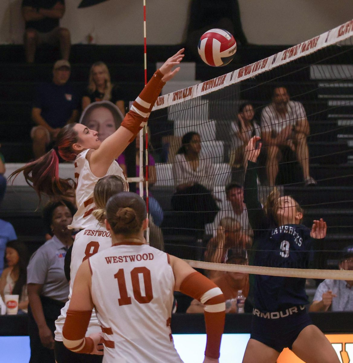 Reaching over the net, opposite hitter Iris Huddleston '28 blocks an incoming ball during the third set. As the closest set among the three, the third set ended 25-15 in a victory for the Warriors.