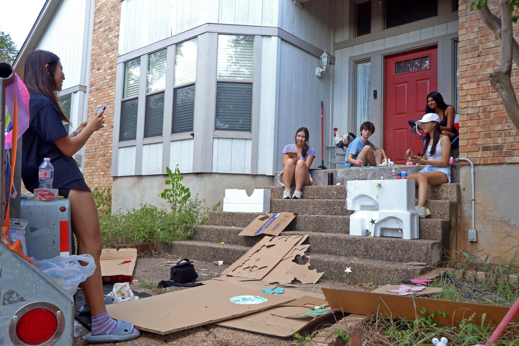 Leaning against a prop, Student Council Sophomore Class President Apple Ma '28 records an Instagram Reel of the volunteers. Despite hours of hard work, the group enjoyed bonding with each other.