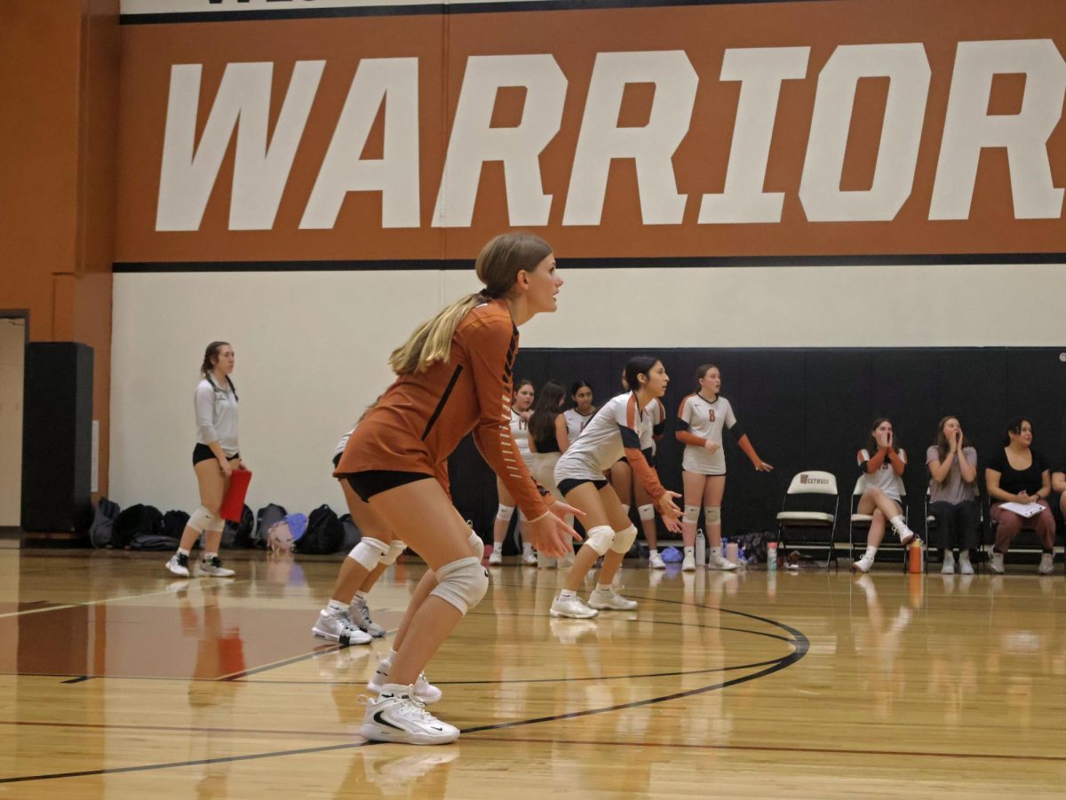Getting low, Emme Sims '29 prepares to receive the ball. Her quick digs helped the Lady Warriors score against the Mavericks.
