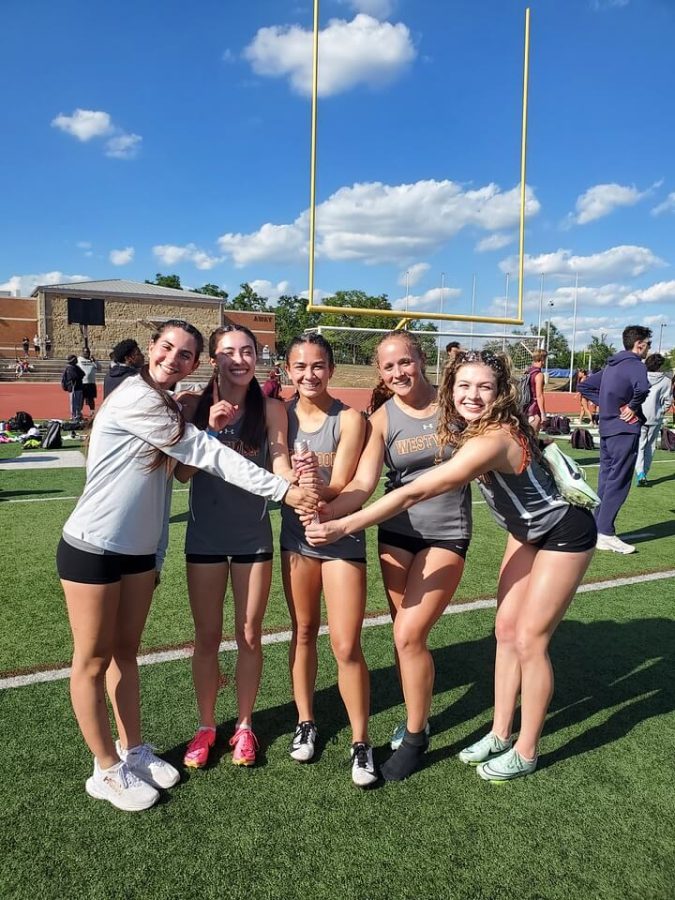 The 4x100 relay team poses after winning their event. The relay team broke their old school record during the district meet.