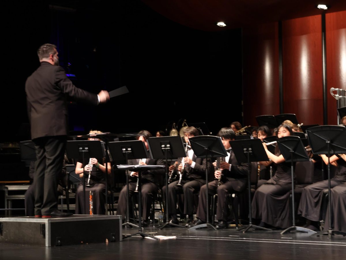 Conducting, Band Director Thomas Turpin leads the Wind Ensemble at their sendoff concert. The Wind Ensemble was chosen to perform at a highly selective program, the Midwest Clinic. “I don’t think there is even a word in the dictionary to describe the emotion I’m feeling,” Mr. Turpin said. “Proud, absolutely, I’m honored to share the stage with these young artists.” 
