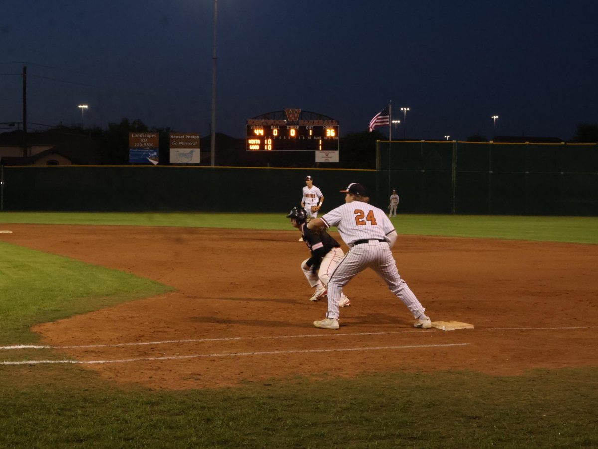 Waiting for the throw back Jacob Wright '25 extends his glove toward the pitchers mound. After a walk the runner planted himself on first base where Wright looked to complete a pick-off and get him off the bases. 