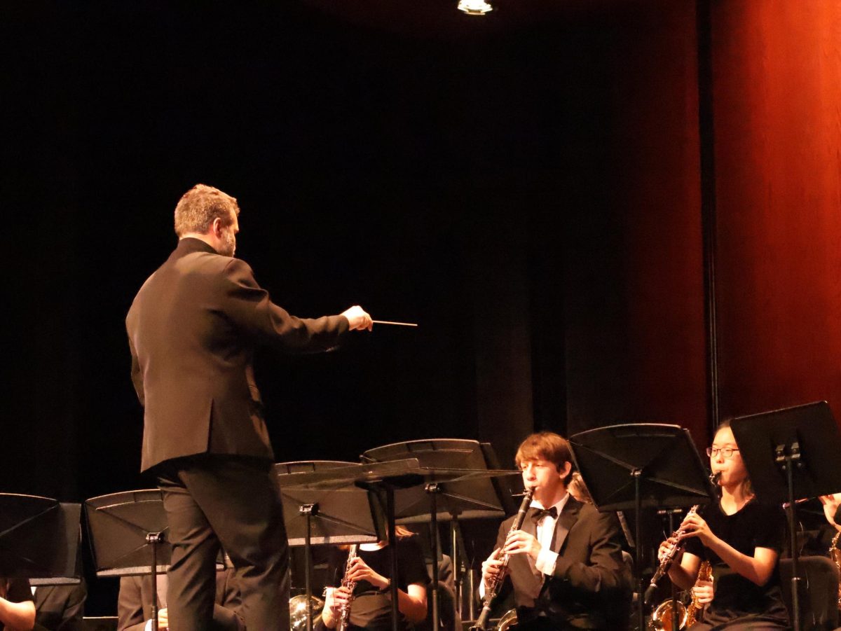 Waving his baton, Head Band Director Thomas Turpin leads the concert band for their spring concert. The concert would mark his last show before his departure from Westwood. "This concert was really special since we got to send off someone who had such a positive impact on us," Adaline Boyd '26 said.