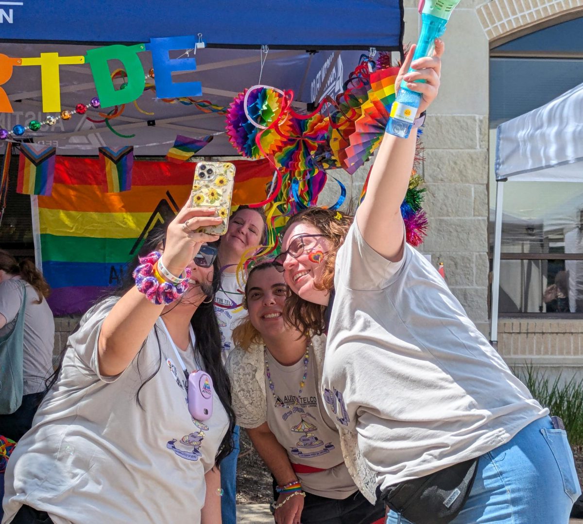 Taking a selfie, three festival attendees celebrate Pride Month by commemorating their time at the festival in front of a colorful backdrop. Many people dressed up for the festival, whether it was colorful makeup, jewelry, special outfits, or full drag looks.